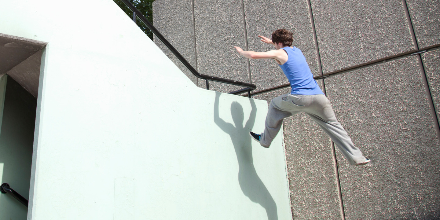 Mann macht im urbanem Umfeld Parcours