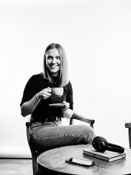 Portrait von Moderatorin Vivi mit Kaffeetasse in der Hand. 