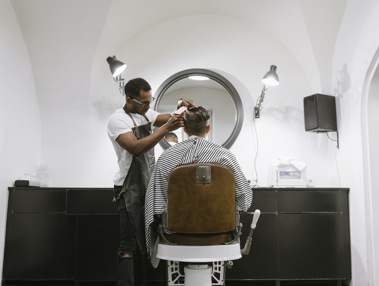Friseur schneidet Kunden die Haare im Friseursalon