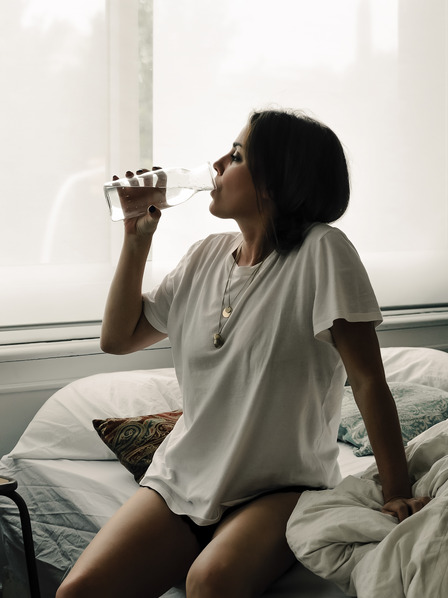 Frau trinkt Wasser am Morgen