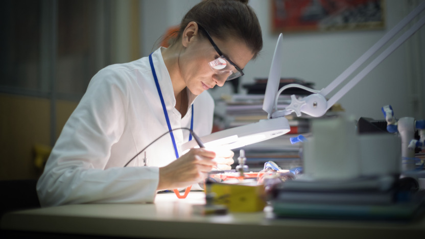 Zahntechnikerin arbeitet an einem Implantat