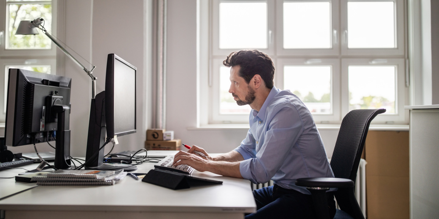 Mann sitzt am Computer im Büro.