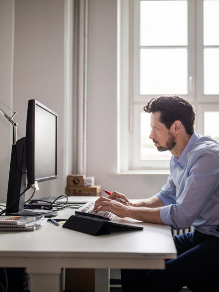 Mann sitzt am Computer im Büro.