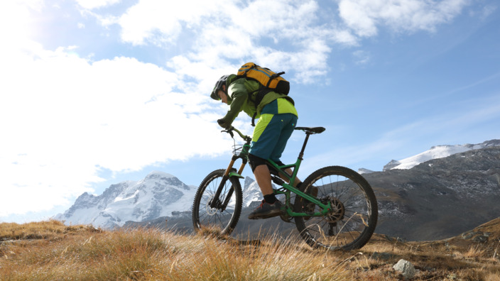 Mann fährt mit Mountainbike den Berg hoch