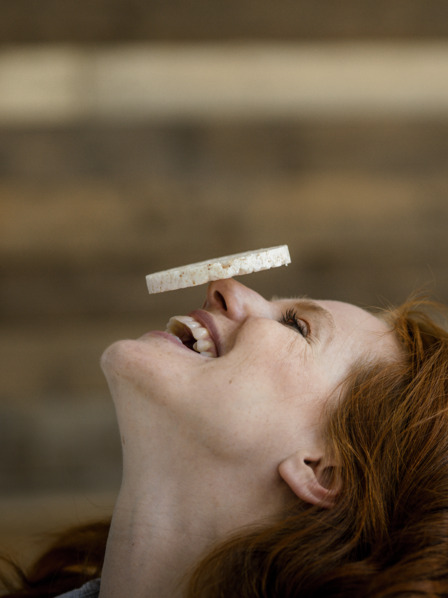 Frau balanciert Reiswaffel auf ihrer Nase und lacht