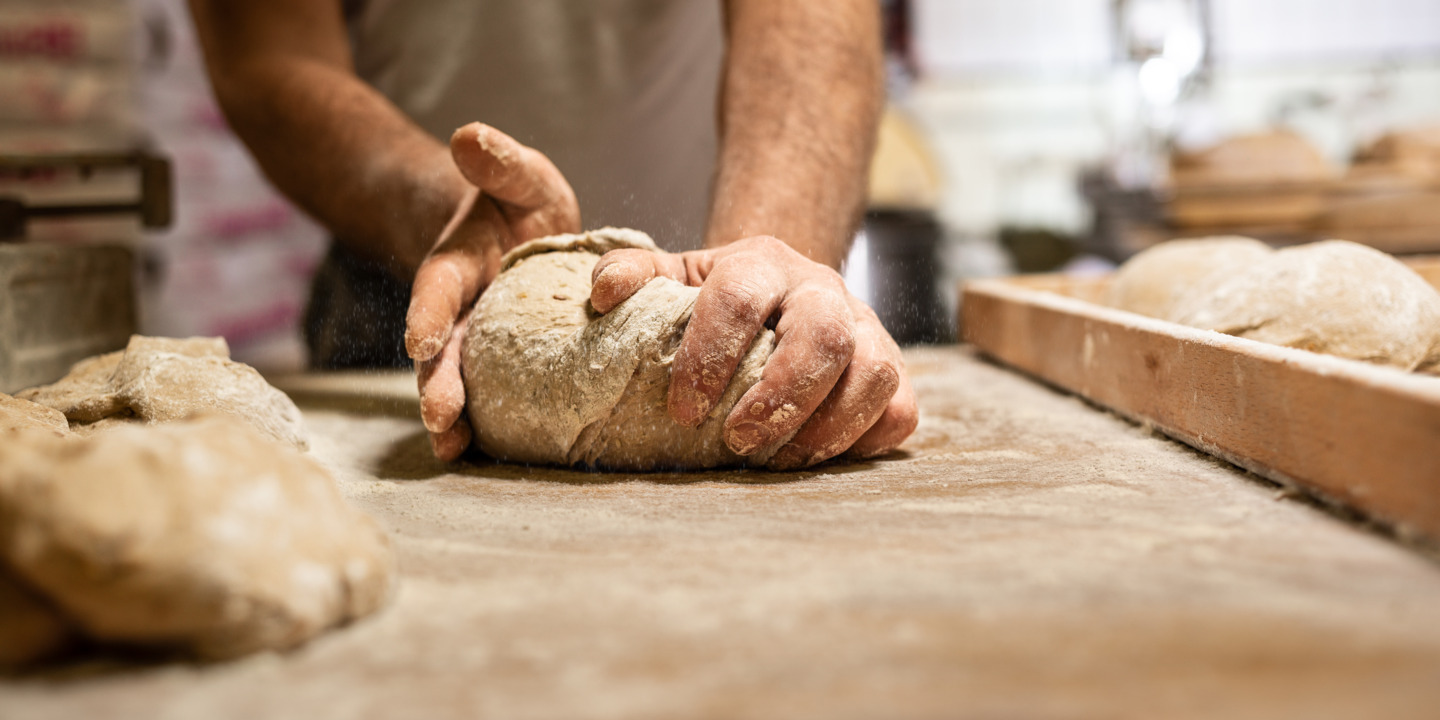 Bäcker beim Formen eines Brotlaibes