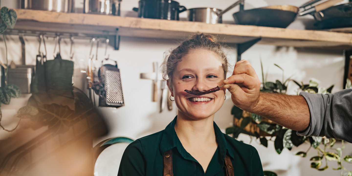 Frau wird eine Chilischote unter die Nase gehalten.