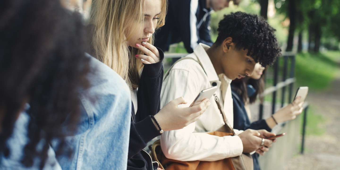 Zwei Jugendliche schauen auf ihr Smartphone