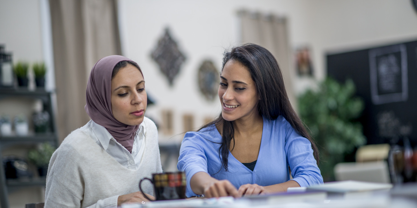 Zwei Frauen sitzen in einem Beratungsgespräch zusammen.