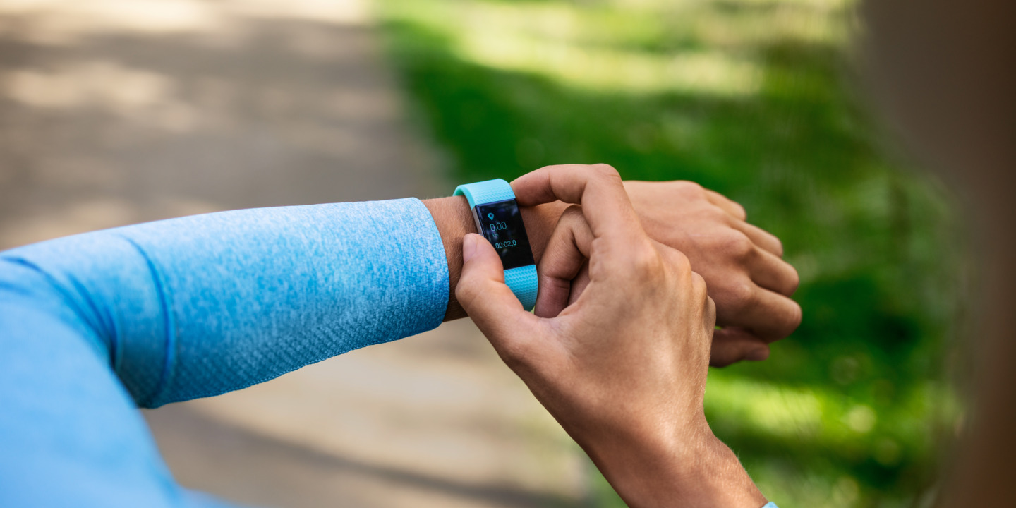 Läuferin im blauen Shirt checkt Smartwatch