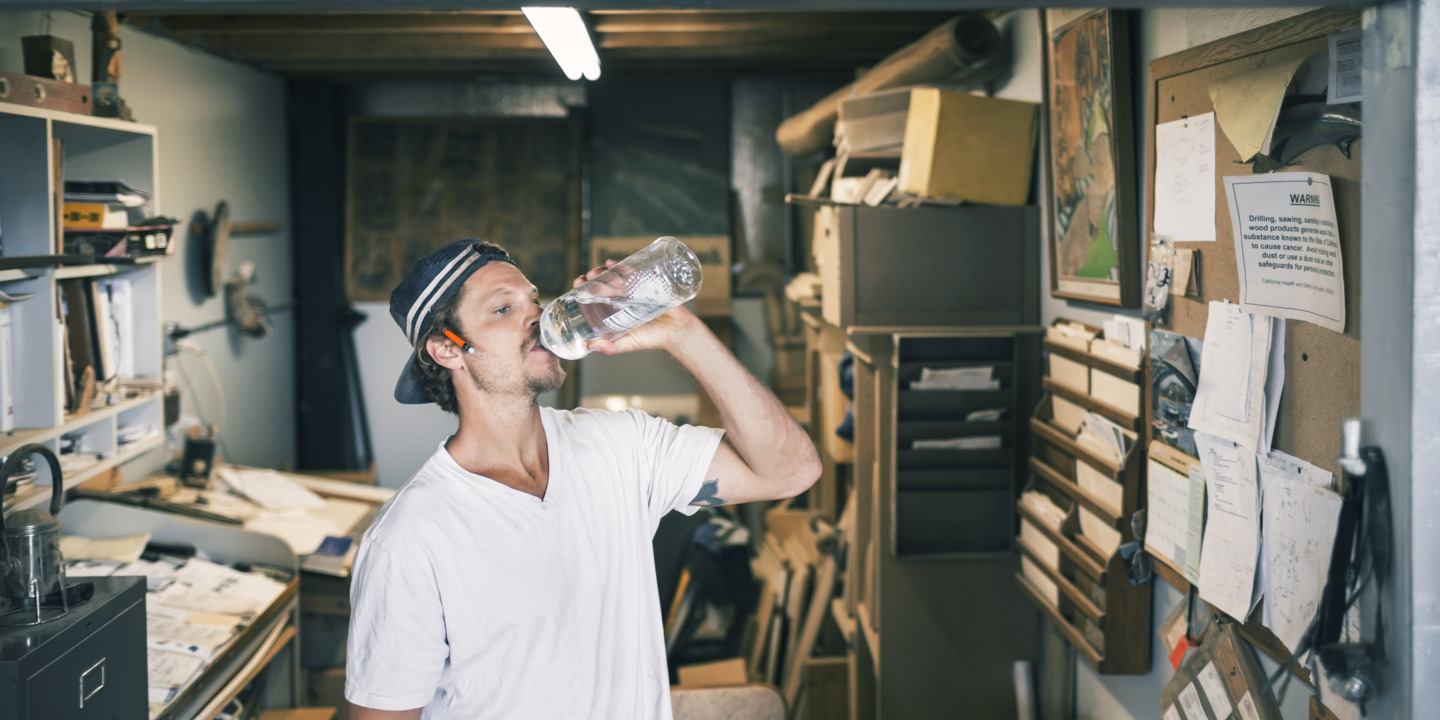 verschwitzter Handwerker trinkt Wasser