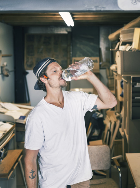 verschwitzter Handwerker trinkt Wasser