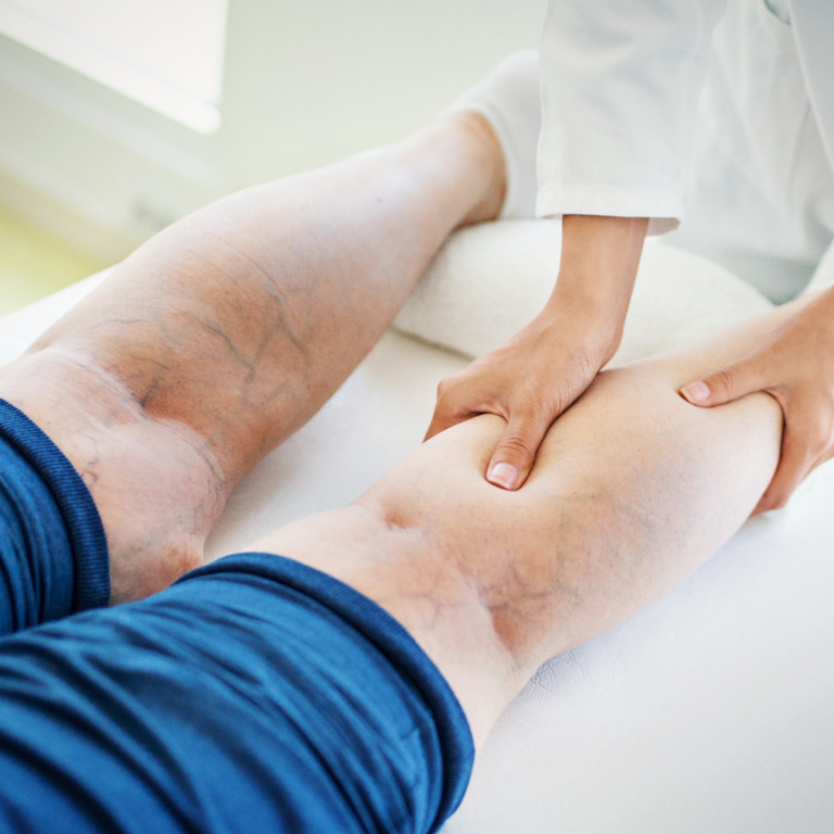 Ärztin kontrolliert die Venen eines Patienten