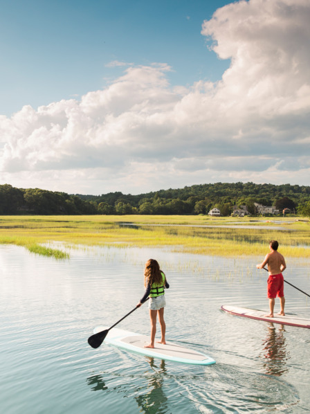 Junge Frau und Mann auf Stand up Paddle am See