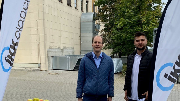 IKK-Mitarbeiter verteilen Äpfel am Infostand