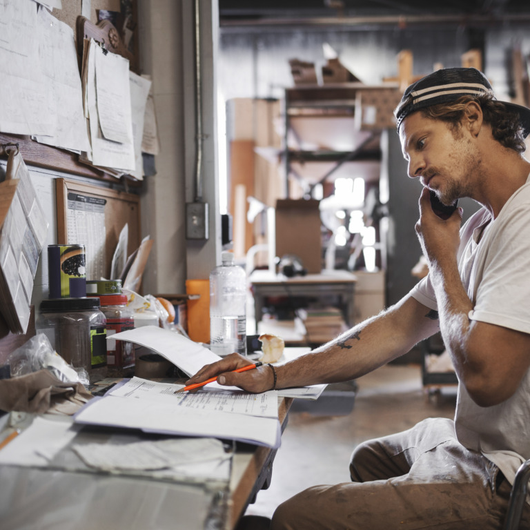 Mitarbeiter im Handwerk telefoniert im Backoffice