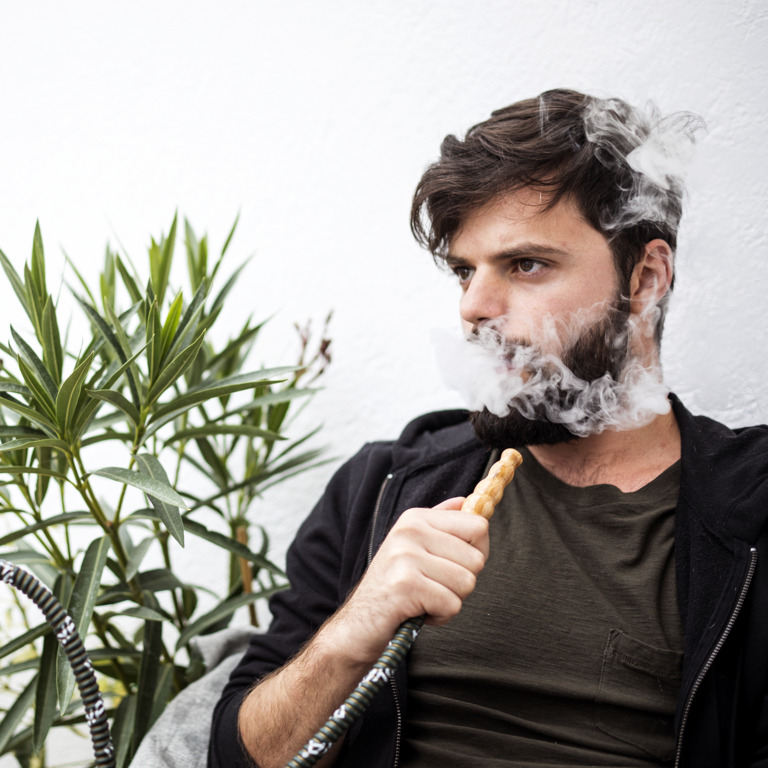 junger Mann raucht eine Shisha
