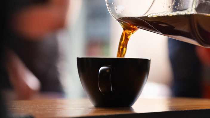 Kaffee wird in eine Tasse gegossen.