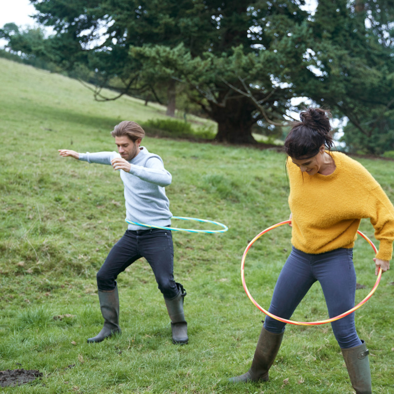 Mann und Frau machen draußen Hula Hoop