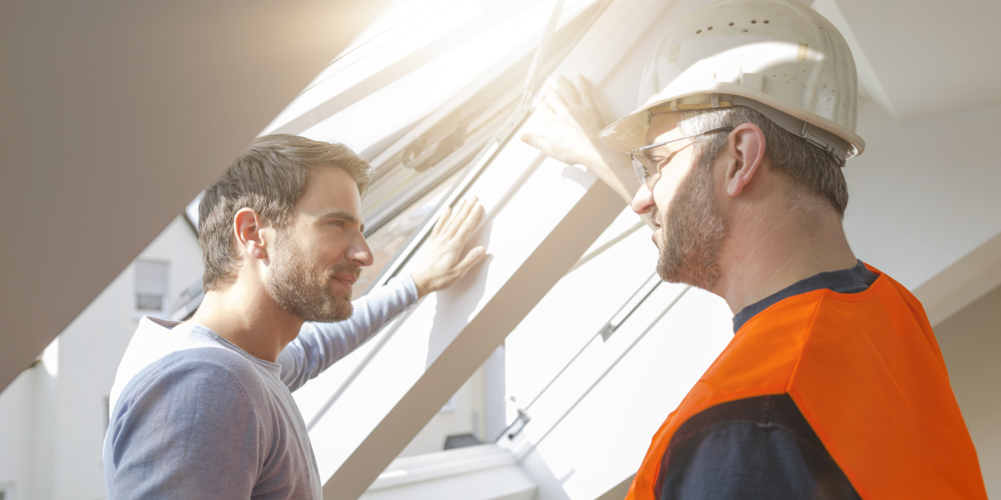 Handwerker mit Warnweste spricht mit Kunden