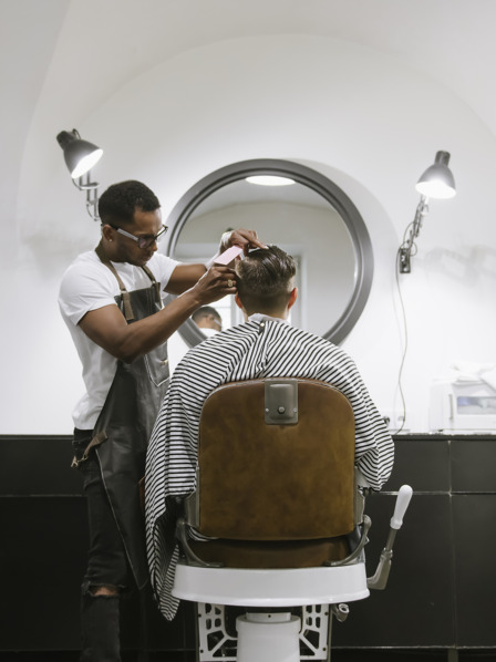 Friseur schneidet Kunden die Haare im Friseursalon