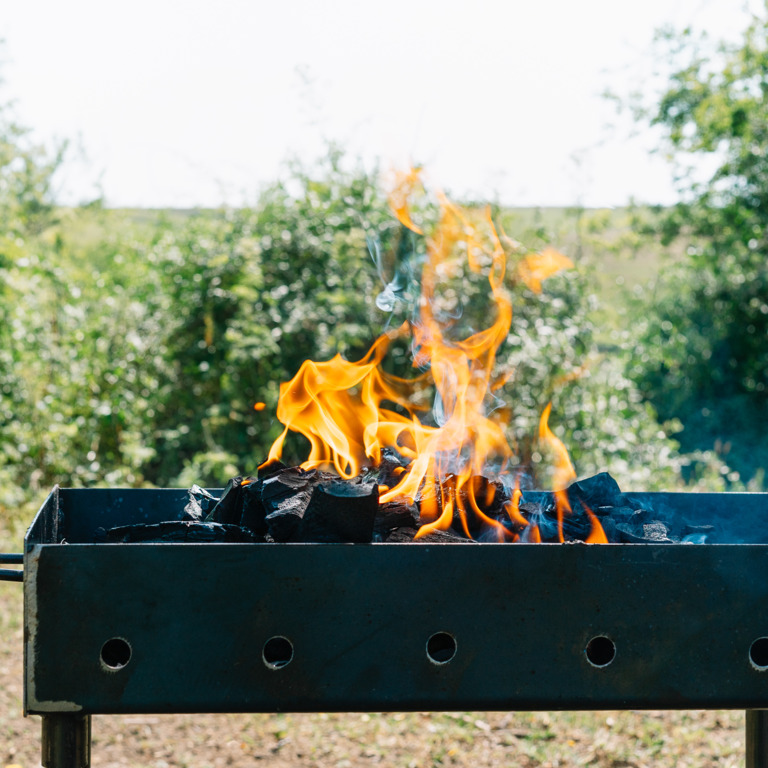 Angefeuerter Grill im Garten