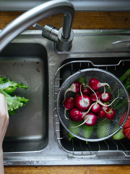 Saisongemüse wie Radieschen und Tomaten in Sieb in Spüle