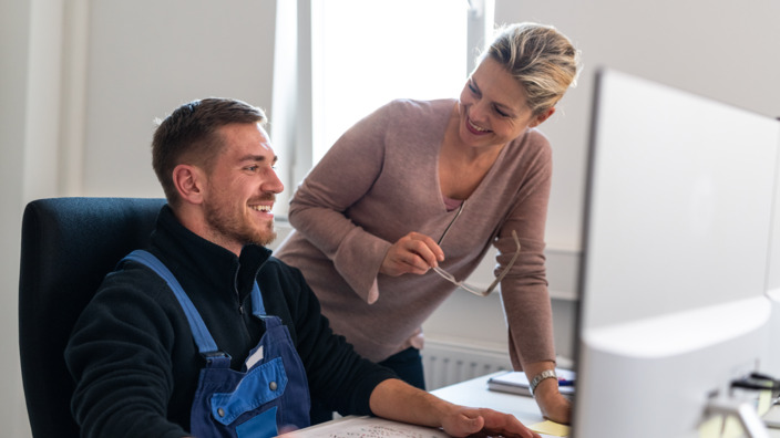 Beraterin überprüft beim Gesundheitstag Ergonomie am Arbeitsplatz 