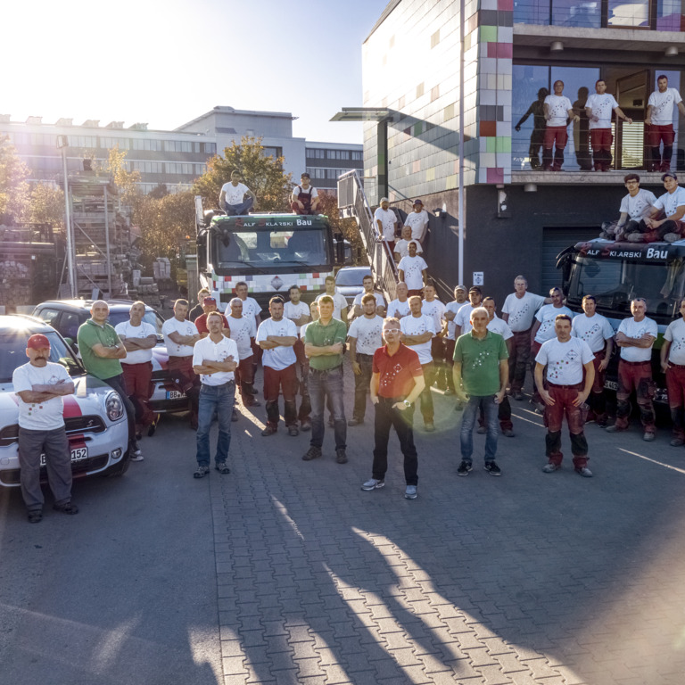 Gruppe von Mitarbeitern steht vor dem Firmengebäude