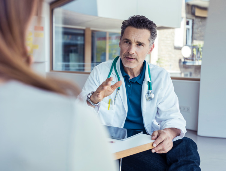 Arzt erklärt Patientin etwas.
