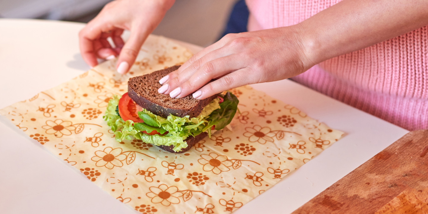 Frau packt Butterbrot in Bienenwachstuch ein