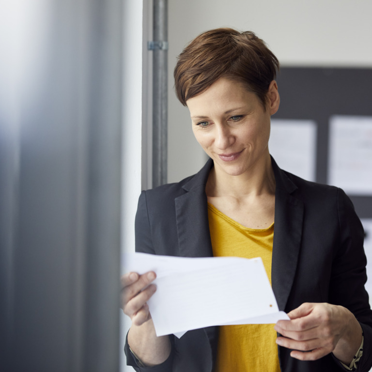 Chefin liest sich ein Arbeitszeugnis durch