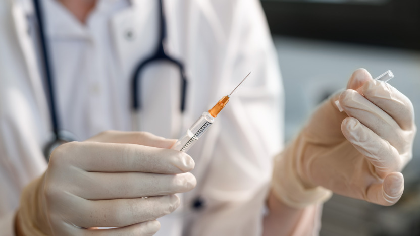 Ärztin hält Spritze mit einer Impfdosis