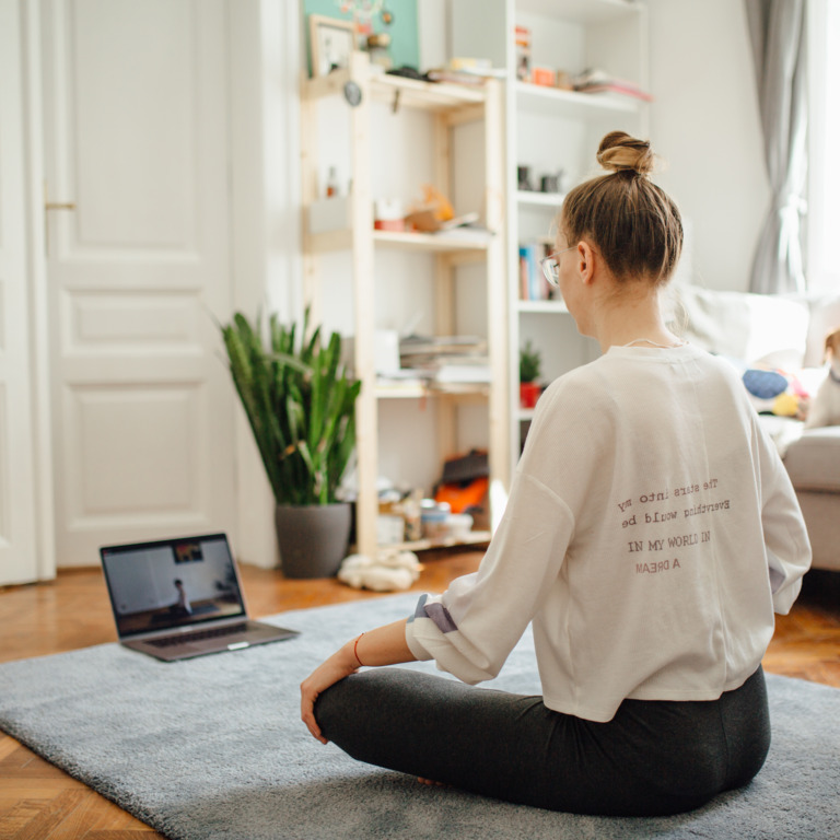 Frau meditiert vor dem Laptop