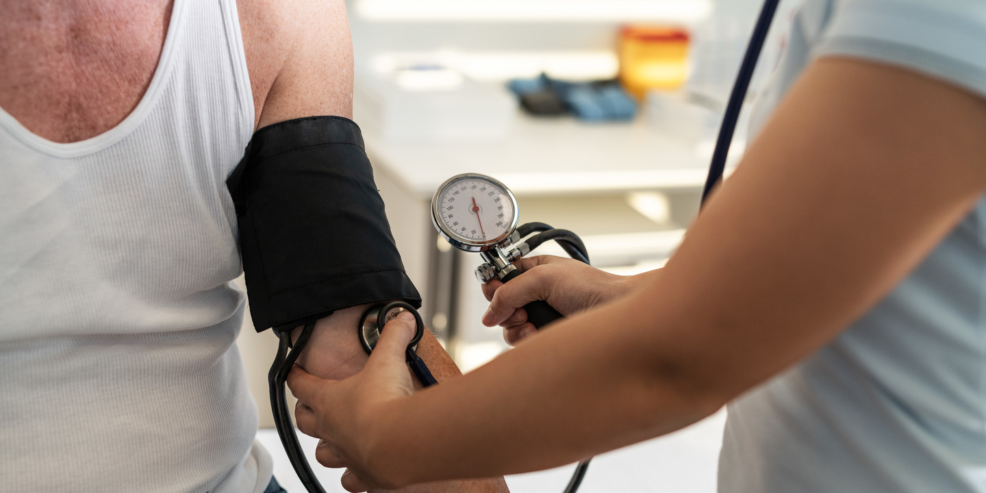 Ärztin misst den Blutdruck eines Patienten