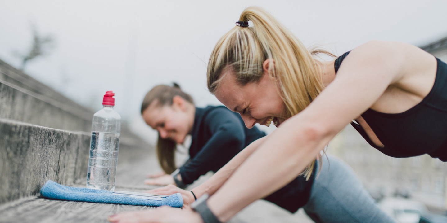 Freundinnen machen push-ups draußen und haben Spass