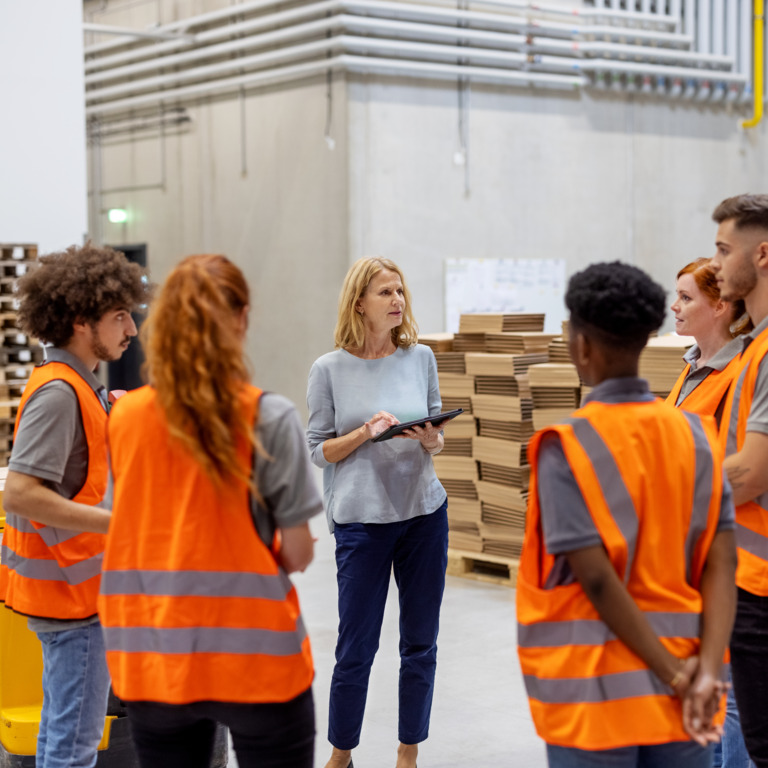 Arbeiter stehen im Kreis und haben ein Teammeeting.