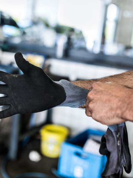 Handwerker zieht einen Arbeitshandschuh an