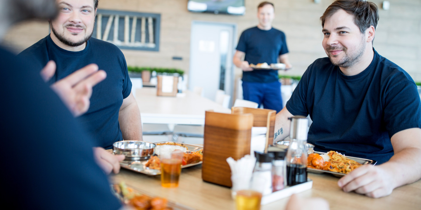 Kollegen essen zusammen in der Kantine