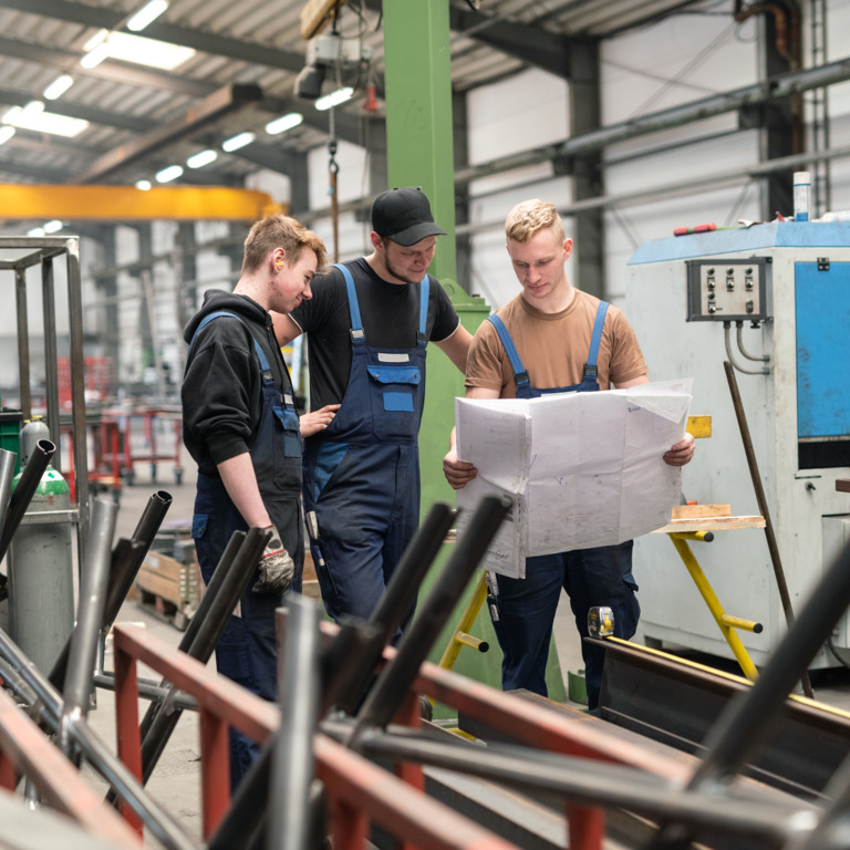 drei Metallbau-Azubis besprechen ein Projekt