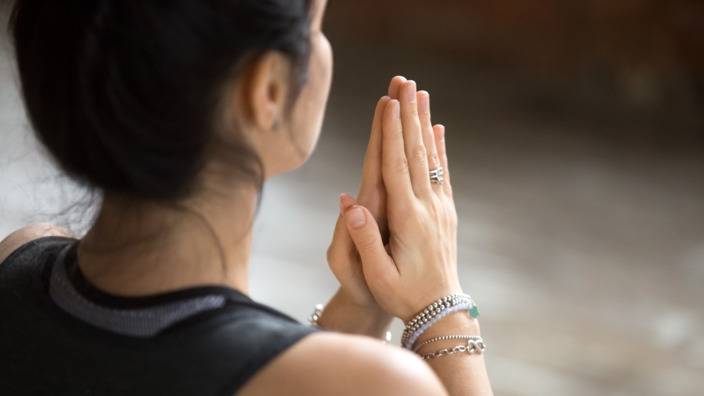 junge Frau entspannt mit Hilfe einer Meditationsübung