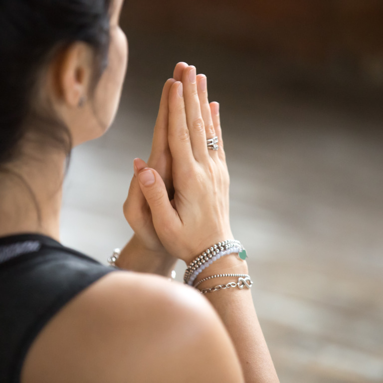 Frau hält betend die Hände