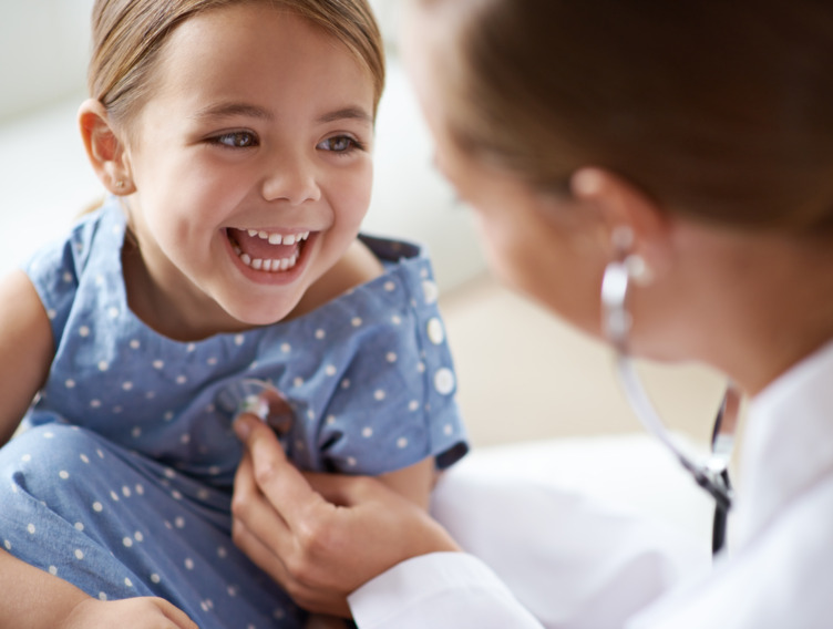 Ärztin hört ein Mädchen mit einem Stethoskop ab