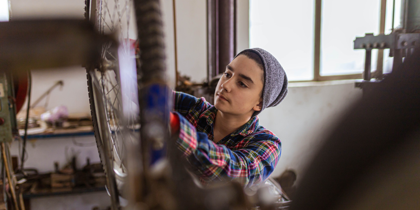 Teenager arbeitet in Fahrradwerkstatt.