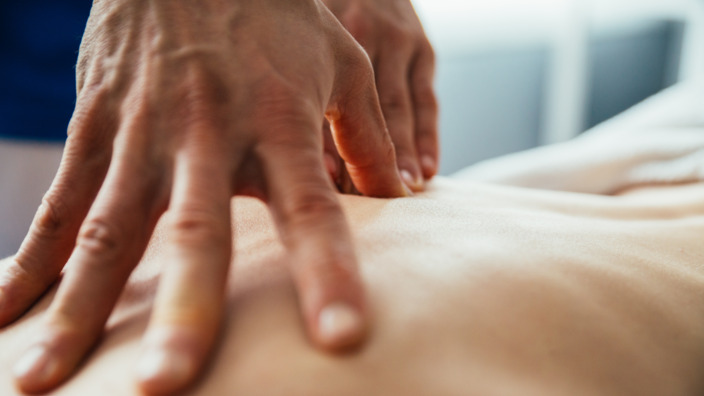 Therapeut behandelt den Rücken eines Patienten