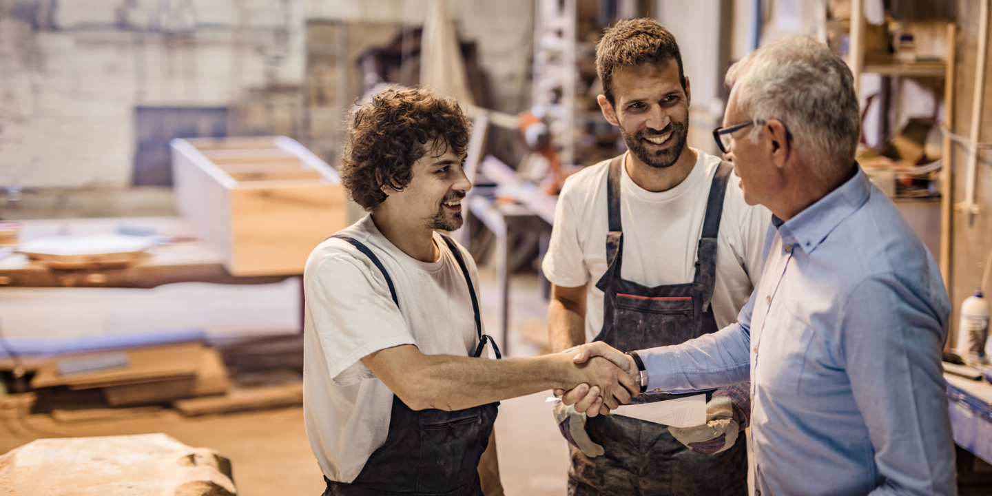 Zwei Handwerker im Gespräch mit einem Kunden