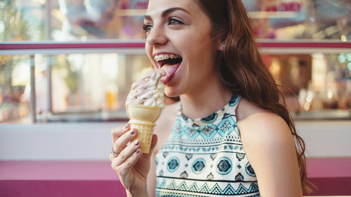 Mädchen mit Zahnspange isst ein Eis