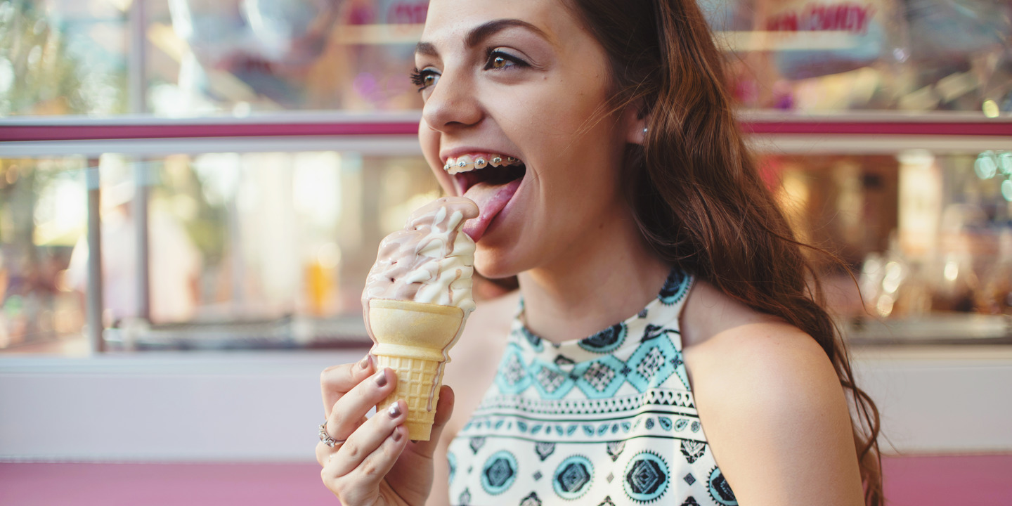 Mädchen mit Zahnspange isst ein Eis