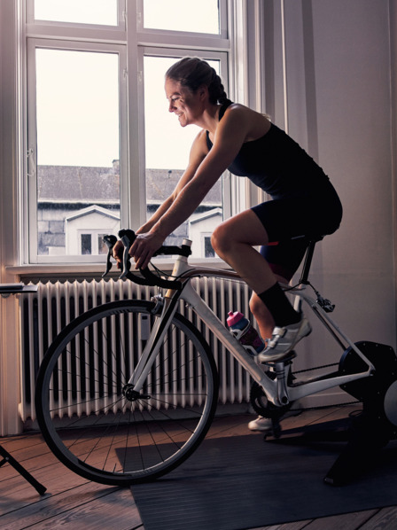 Frau auf einem Fahrrad-Hometrainer Zuhause.