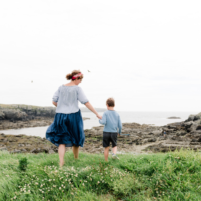 Mutter und Sohn wandern entlang eines Feldweges an der Küste